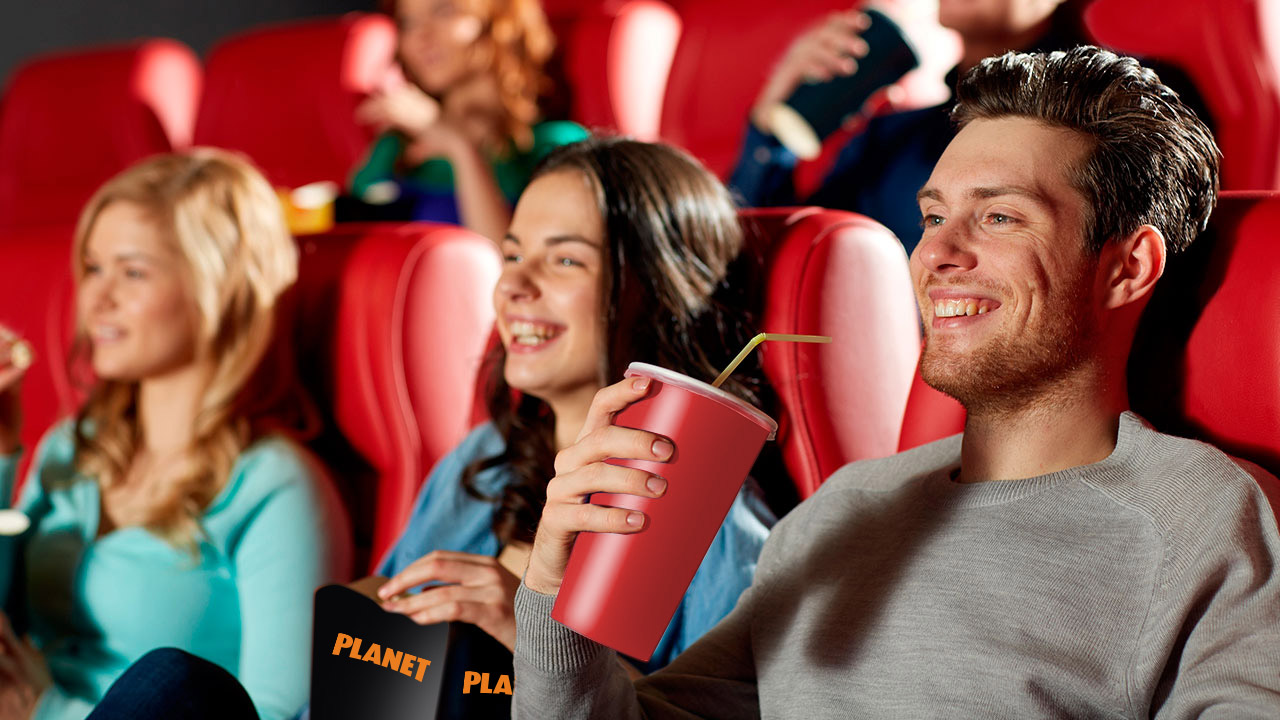 קבוצת צעירים יושבים באולם קולנוע עם פופקורן ושתייה